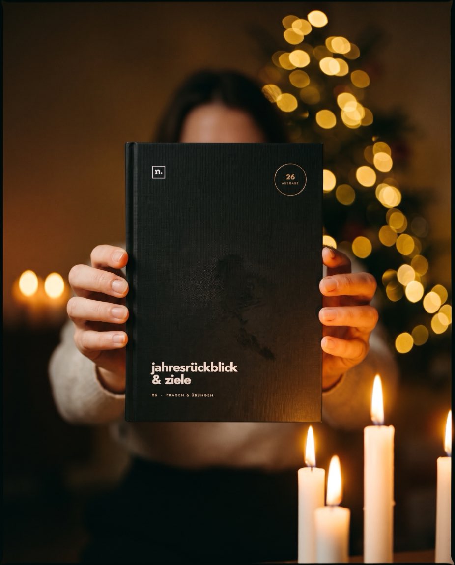 Zwei Hände halten die fertige Ausgabe 26 bei Kerzenlicht vor sich, im Hintergrund der Weihnachtsbaum