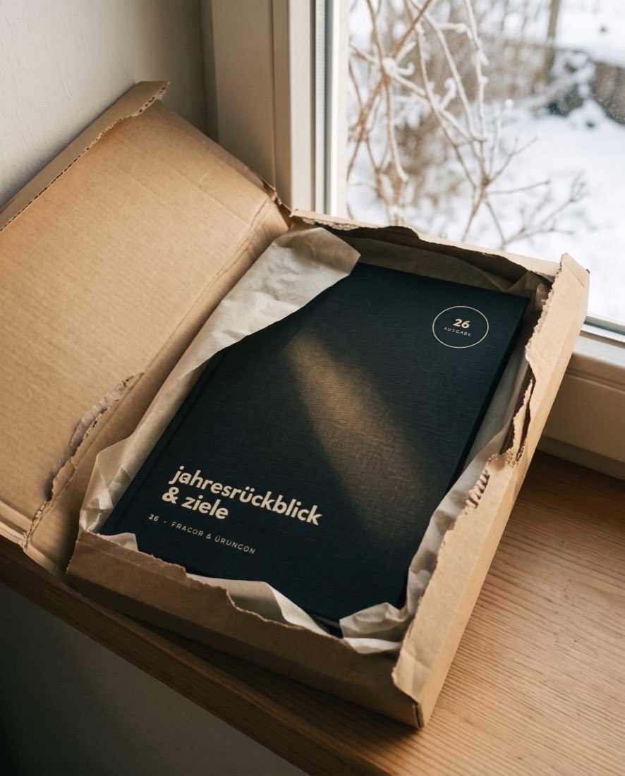 Das flache Paket wird am Fenster geöffnet, die Ausgabe 26 liegt in Seidenpapier