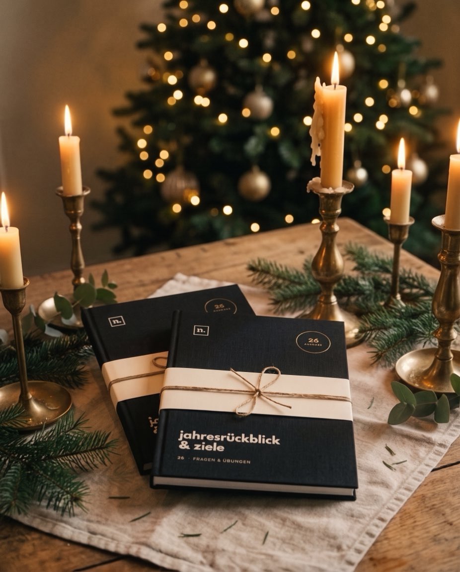 Zwei Exemplare der Ausgabe 26 mit Banderole bei Kerzenlicht, im Hintergrund ein geschmückter Weihnachtsbaum